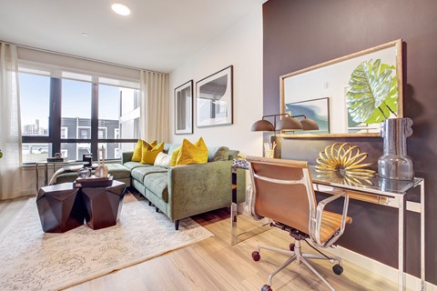 a living room with a couch and a desk with a chair